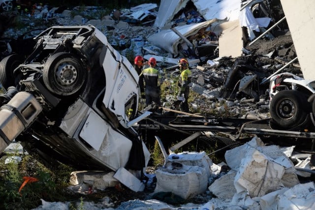 The front cabin of a truck that fell from the collapsed section of the A10 freeway lies overturned. Photo: Andrea Leoni / AFP